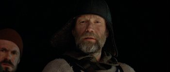 Movie still from “Rare Exports” (2010), directed by Jalmari Helander – A man with a beard wearing a hat and a sweater; Close Up shot, Low angle