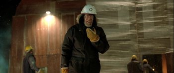 Movie still from “Rare Exports” (2010), directed by Jalmari Helander – An older man wearing a winter coat and a helmet; Medium shot, Over the shoulder angle