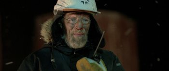 Movie still from “Rare Exports” (2010), directed by Jalmari Helander – An older man wearing a white hat and glasses; Close Up shot, Over the shoulder angle