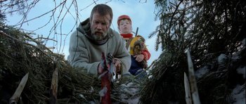 Movie still from “Rare Exports” (2010), directed by Jalmari Helander – A man and a boy in the woods with trees; Medium shot, Low angle