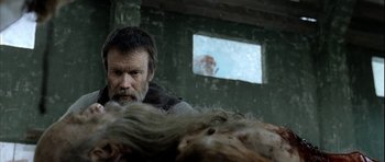 Movie still from “Rare Exports” (2010), directed by Jalmari Helander – A man with a beard is looking at a dead body; Close Up shot, Over the shoulder angle
