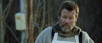 Movie still from “Rare Exports” (2010), directed by Jalmari Helander – A man with a beard wearing an overalls; Close Up shot, Low angle