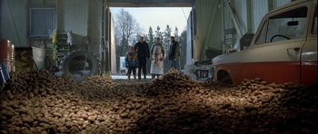 Movie still from “Rare Exports” (2010), directed by Jalmari Helander – A group of people standing in front of a pile of potatoes; Extreme Wide shot, Low angle