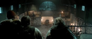 Movie still from “Rare Exports” (2010), directed by Jalmari Helander – Two people watching a gorilla in an indoor setting; Wide shot, Over the shoulder angle
