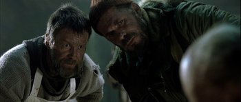 Movie still from “Rare Exports” (2010), directed by Jalmari Helander – Two men standing next to each other in a room; Close Up shot, Low angle