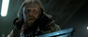 Movie still from “Rare Exports” (2010), directed by Jalmari Helander – A man with long hair and a goatee is looking at the camera; Close Up shot, Low angle