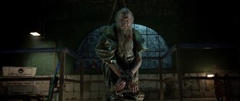 Movie still from “Rare Exports” (2010), directed by Jalmari Helander – An old man chained to a metal pole; Medium shot, Low angle