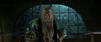 Movie still from “Rare Exports” (2010), directed by Jalmari Helander – A man with long hair and a long beard is chained up; Close Up shot, High angle