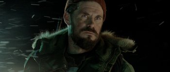 Movie still from “Rare Exports” (2010), directed by Jalmari Helander – A person with a beard wearing a hat; Close Up shot, Low angle