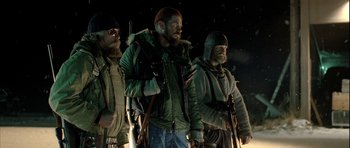 Movie still from “Rare Exports” (2010), directed by Jalmari Helander – A group of men standing next to each other on a field; Medium shot, Low angle