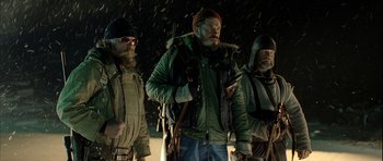 Movie still from “Rare Exports” (2010), directed by Jalmari Helander – A group of men standing next to each other holding guns; Medium shot, Low angle