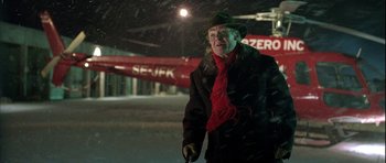 Movie still from “Rare Exports” (2010), directed by Jalmari Helander – An older man in a green hat and a red plane in the background; Medium shot, Over the shoulder angle