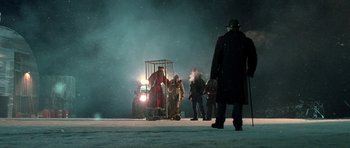 Movie still from “Rare Exports” (2010), directed by Jalmari Helander – A group of people standing around a car on a snowy night; Wide shot, Low angle