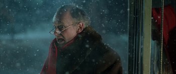 Movie still from “Rare Exports” (2010), directed by Jalmari Helander – An old man wearing glasses and a red and black scarf; Close Up shot, Low angle