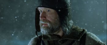 Movie still from “Rare Exports” (2010), directed by Jalmari Helander – A man with a beard wearing a black hat; Close Up shot, Over the shoulder angle