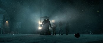 Movie still from “Rare Exports” (2010), directed by Jalmari Helander – A group of people standing in the snow near a vehicle; Extreme Wide shot, Low angle