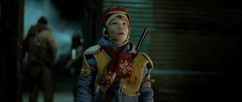 Movie still from “Rare Exports” (2010), directed by Jalmari Helander – A young boy wearing a winter coat and a hat; Close Up shot, Low angle