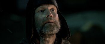 Movie still from “Rare Exports” (2010), directed by Jalmari Helander – A man with a beard wearing a black hat; Close Up shot, Low angle