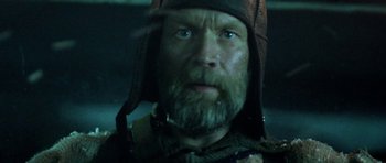 Movie still from “Rare Exports” (2010), directed by Jalmari Helander – A person with a beard wearing a hat; Close Up shot, Low angle