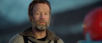 Movie still from “Rare Exports” (2010), directed by Jalmari Helander – A person with a beard looking at the camera; Close Up shot, Low angle