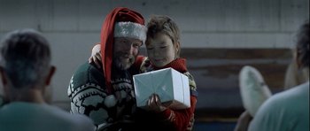 Movie still from “Rare Exports” (2010), directed by Jalmari Helander – A man and a boy holding a gift box; Close Up shot, Over the shoulder angle