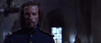 Movie still from “Ravenous” (1999), directed by Antonia Bird – A person wearing a uniform; Close Up shot, Low angle