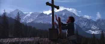 Movie still from “Ravenous” (1999), directed by Antonia Bird – A person standing next to a wooden cross; Wide shot, Low angle