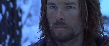 Movie still from “Ravenous” (1999), directed by Antonia Bird – A person with long hair and blue eyes; Close Up shot, Low angle