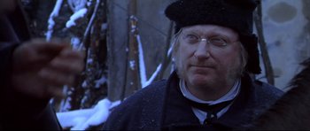 Movie still from “Ravenous” (1999), directed by Antonia Bird – A man wearing a hat and glasses standing in the snow; Close Up shot, Over the shoulder angle