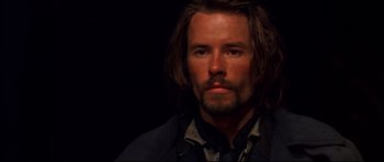 Movie still from “Ravenous” (1999), directed by Antonia Bird – A person with long brown hair and a beard; Close Up shot, High angle