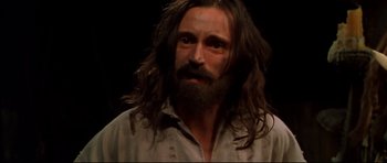 Movie still from “Ravenous” (1999), directed by Antonia Bird – A man with long hair and a long beard; Close Up shot, High angle