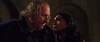 Movie still from “Ravenous” (1999), directed by Antonia Bird – A man standing next to a woman in a room; Close Up shot, Over the shoulder angle