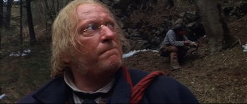 Movie still from “Ravenous” (1999), directed by Antonia Bird – An old man with blonde long hair wearing glasses; Close Up shot, Low angle