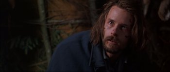 Movie still from “Ravenous” (1999), directed by Antonia Bird – A person with long hair and a beard; Close Up shot, Low angle