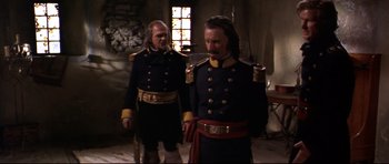 Movie still from “Ravenous” (1999), directed by Antonia Bird – A couple of men in military uniforms standing next to each other; Medium shot, Over the shoulder angle