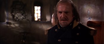 Movie still from “Ravenous” (1999), directed by Antonia Bird – An older man in a military uniform looking at the camera; Close Up shot, Over the shoulder angle