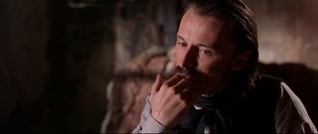 Movie still from “Ravenous” (1999), directed by Antonia Bird – A person with a mustache; Close Up shot, Over the shoulder angle