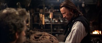 Movie still from “Ravenous” (1999), directed by Antonia Bird – A man standing next to a bag of potatoes; Medium shot, Over the shoulder angle