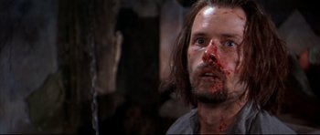 Movie still from “Ravenous” (1999), directed by Antonia Bird – A person with blood all over his face; Close Up shot, Over the shoulder angle