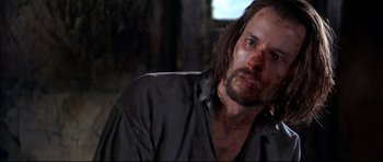 Movie still from “Ravenous” (1999), directed by Antonia Bird – A person wearing a shirt; Close Up shot, Over the shoulder angle