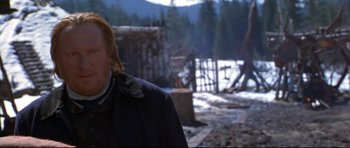 Movie still from “Ravenous” (1999), directed by Antonia Bird – A woman standing in front of a tree stump; Close Up shot, Over the shoulder angle