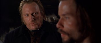 Movie still from “Ravenous” (1999), directed by Antonia Bird – Two men in suits and ties looking at each other; Close Up shot, Over the shoulder angle