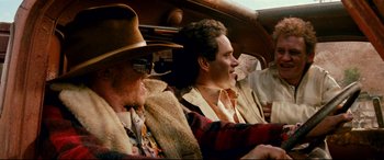 Movie still from “Razorback” (1984), directed by Russell Mulcahy – Two men sitting in the back seat of a car; Medium shot, Low angle