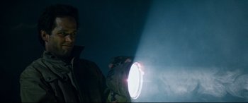 Movie still from “Razorback” (1984), directed by Russell Mulcahy – A man is holding a flashlight in the dark; Close Up shot, Low angle