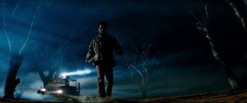 Movie still from “Razorback” (1984), directed by Russell Mulcahy – A man standing on top of a hill at night; Wide shot, Low angle