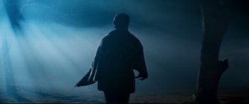 Movie still from “Razorback” (1984), directed by Russell Mulcahy – A person walking on a beach in the dark; Wide shot, Low angle