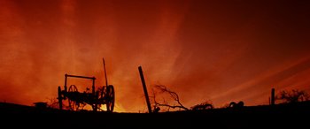 Movie still from “Razorback” (1984), directed by Russell Mulcahy – A red sky with a fire in the background; Extreme Wide shot, Low angle