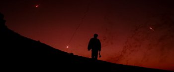 Movie still from “Razorback” (1984), directed by Russell Mulcahy – A man standing on top of a hill at night; Extreme Wide shot, Low angle