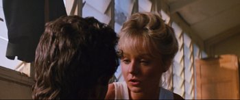 Movie still from “Razorback” (1984), directed by Russell Mulcahy – A young woman sitting in front of another woman; Close Up shot, Over the shoulder angle