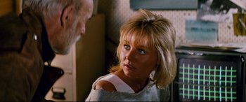 Movie still from “Razorback” (1984), directed by Russell Mulcahy – A woman with blonde hair and blue eyes looking at a man; Close Up shot, Over the shoulder angle